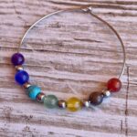 Pendientes Chakra de Acero con siete bolitas de cristal.